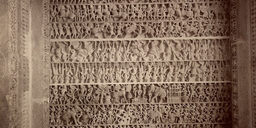 Inside the Dilwara temple with its fine carved ceiling showing human and animal figures.