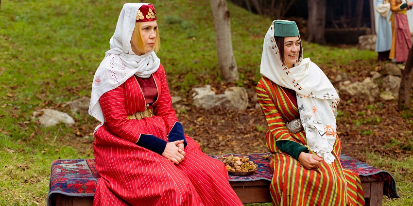 Wooden houses, traditional fabrics, and folk displays show Tatar cultural life in a village-style setting.