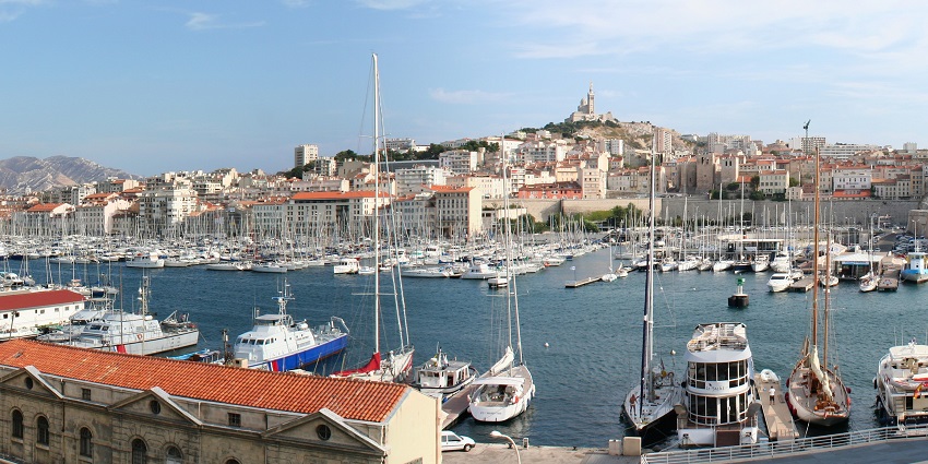 Docked luxury yachts and boats at a serene marina with clear reflections in calm waters.