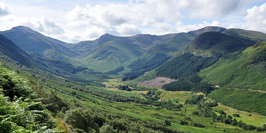 Scenic drive through winding mountain roads bathed in silver moonlight and dramatic Highland shadows.
