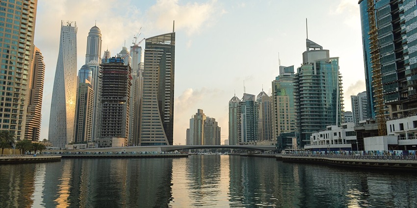 Dubai Marina Walk in the day with skyscrapers lining the waterfront under a clear sky