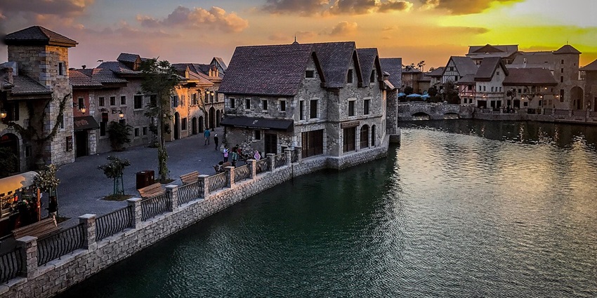 Sunset view of Riverland at Dubai Parks and Resorts with a colourful sky and calm river.