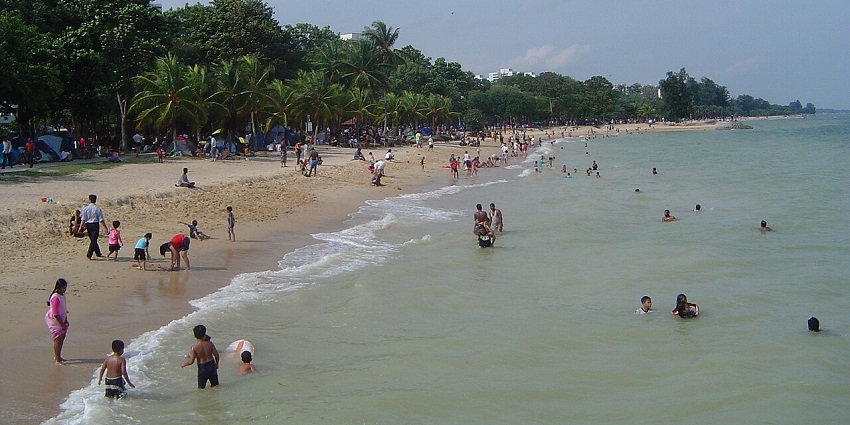 The beach at East Coast Park is filled with visitors enjoying the sun, sand, and activities, one of the best places to visit in Singapore in September.
