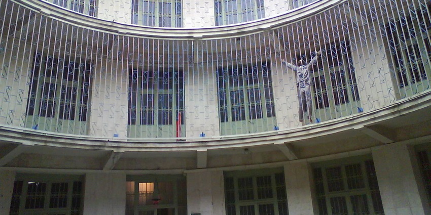 Interior of the Ebrat museum with multiple prison cell gates and a museum doll hanging