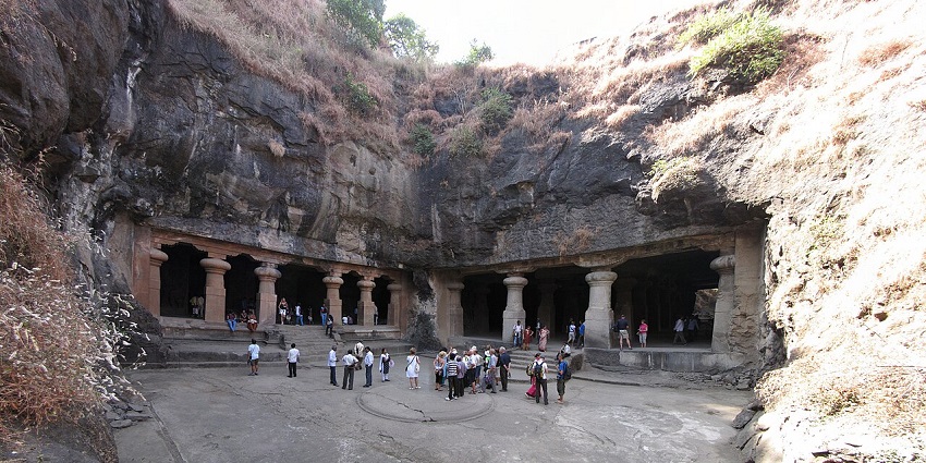 Ancient rock-cut cave temples with stone sculptures of Hindu deities on Elephanta Island.
