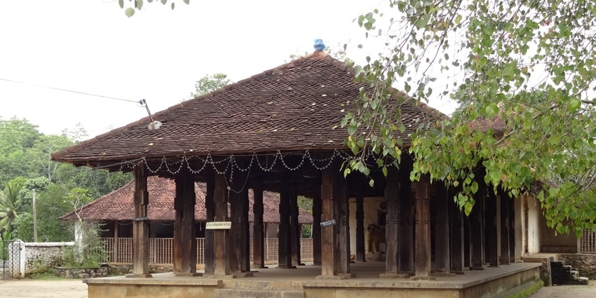 Wooden pillars with intricate carvings inside the Embekka Devalaya temple, one of the historical places in Kandy.