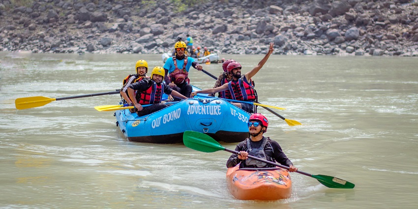 Travellers in a small boat float gently down a calm, tree-lined river surrounded by greenery.