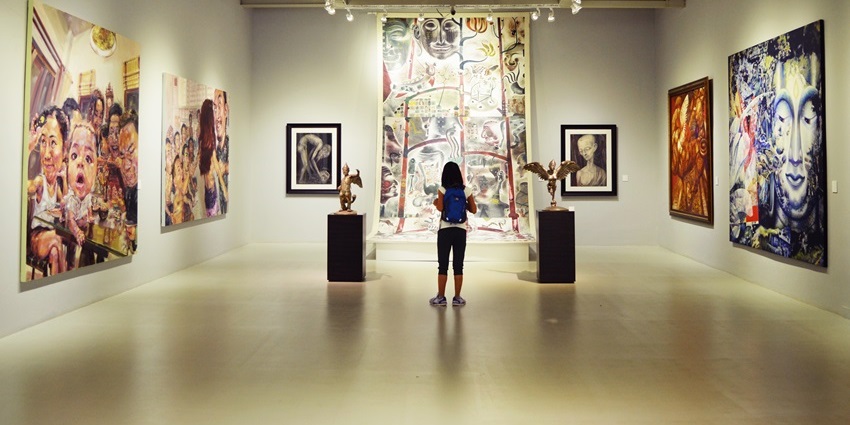 Image of art lover admiring local paintings and sculptures inside the Madeley Gallery