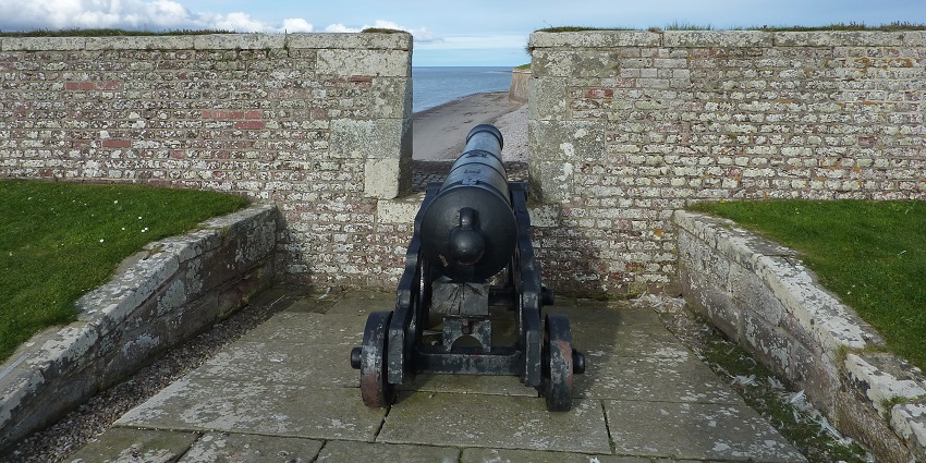 Historic Old Fort Madison with mounted cannons overlooking a grassy field, displaying early American military architecture.