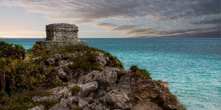 Marvel at clifftop Mayan ruins overlooking turquoise waters along the Tulum coastline.