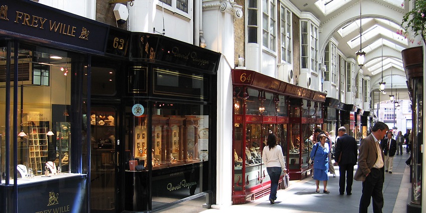 Elegant interior of Burlington Arcade with aesthetic architecture, glass roof, and boutique shops.