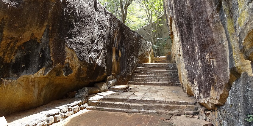 Natural rock formations and shaded trails showcasing Sigiriya’s defensive architecture and monastic heritage amid forested terrain.