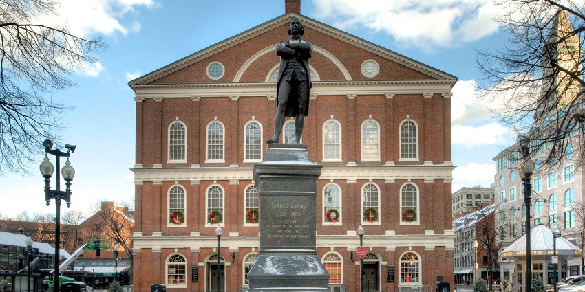 Statue of Samuel Adams in front of historic Faneuil Hall, Boston, under the blue sky