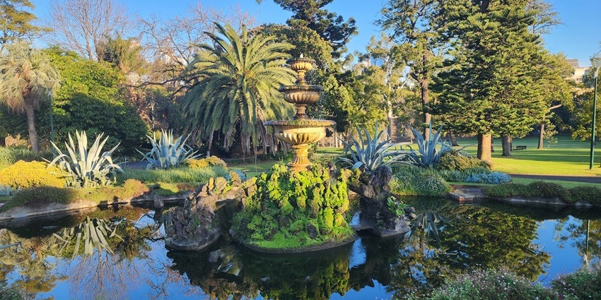 Lush greenery and pathways inside Fitzroy Gardens, one of the historical places in Melbourne.