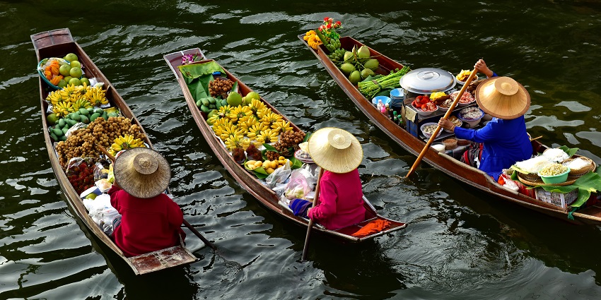 Female vendors on their boat(sampan) in narrow canals for sale their products