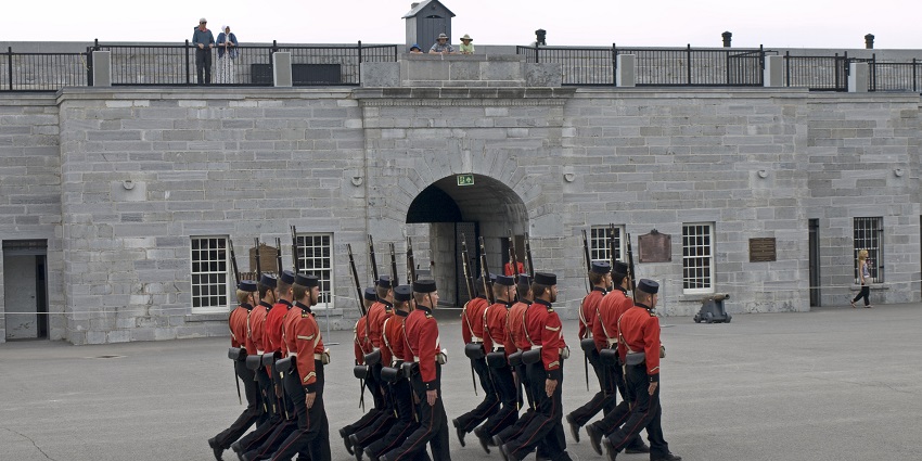 Costumed guards march near the stone walls of Fort Henry in Kingston, one of the top historical places in Ontario.