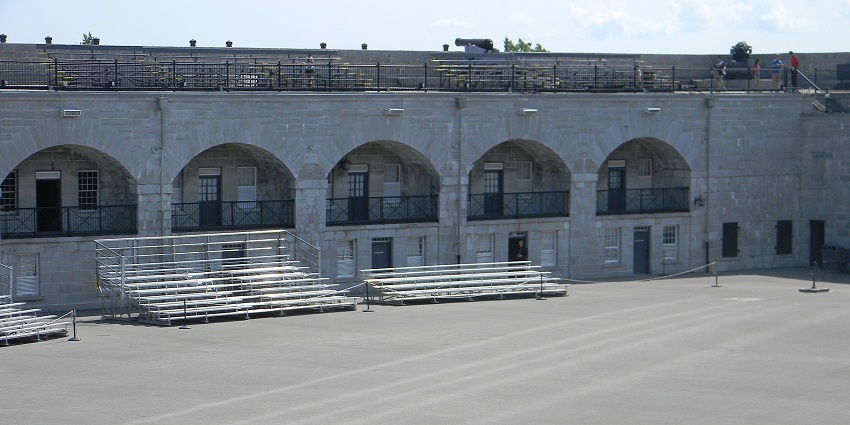 Kingston Fort Henry in Ontario with traditional architecture, people sitting and black fencing