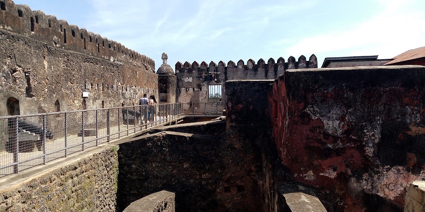 A couple walking inside the historic Fort Jesus in Mombasa, Kenya, exploring the site.