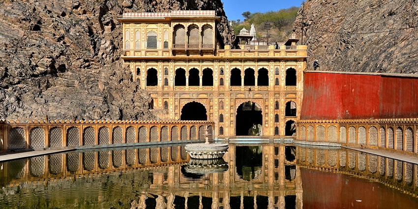 Sacred temple complex with bathing tanks nestled in hills, often filled with playful monkeys.