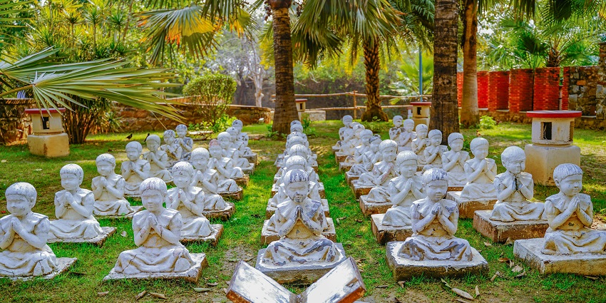 Garden of Five Senses in Delhi with white detailed sculptures on stone platforms.