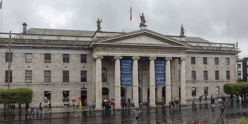 Crowd of people walking in front of Dublin’s General Post Office (GPO) on a lively street