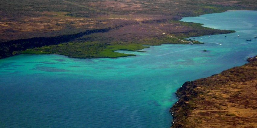 Aerial view of a coastal landscape with blue-green waters, one of the islands in Ecuador