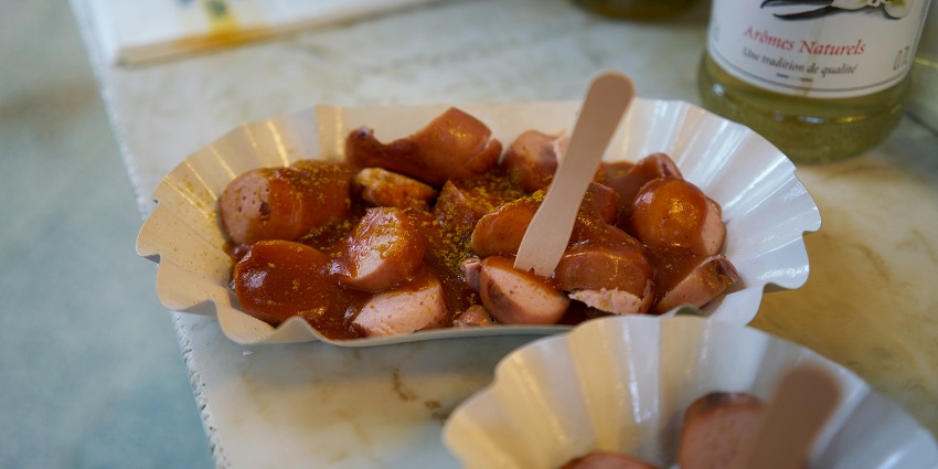 Popular German sausage snack served with dipping sauce over it.