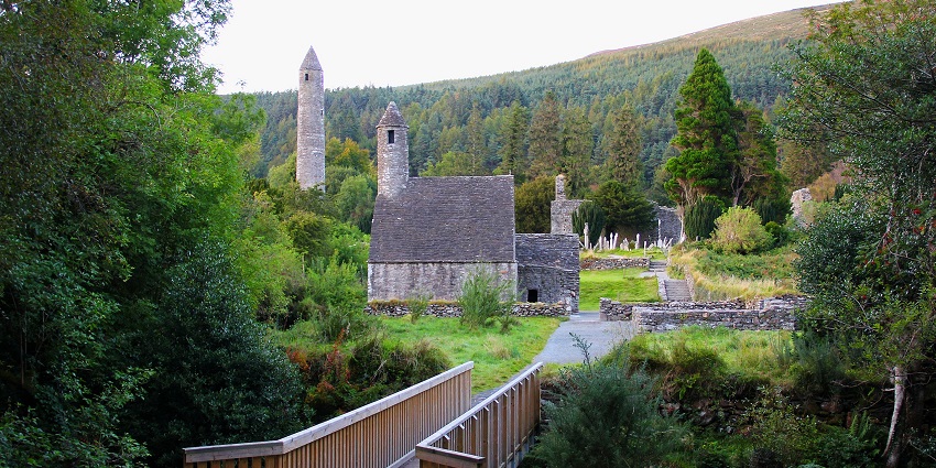 Glendalough Monastic City ruins nestled in lush green valley with ancient stone structures