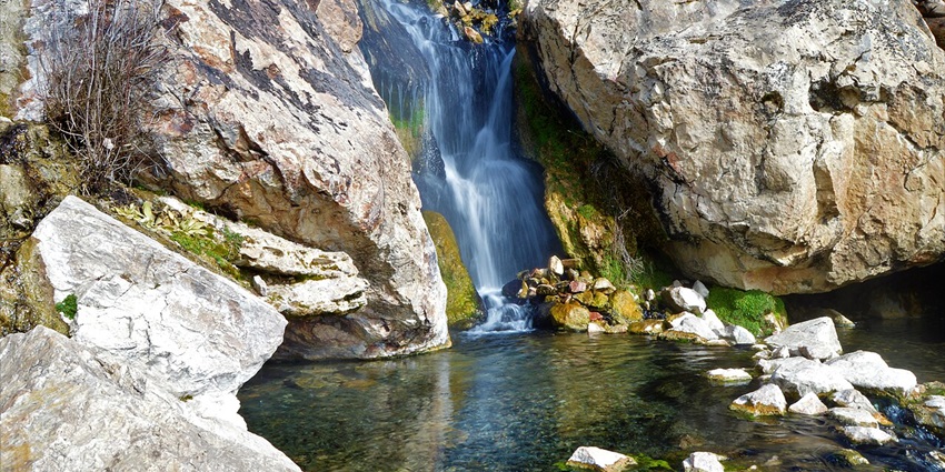 Goldbug hot springs with the hot water falling into the pond surrounded by big rocks.