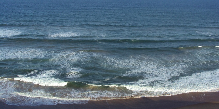 A scenic view of Gopalpur Beach with waves crashing at the shoreline, one of the places to visit in Odisha in March.