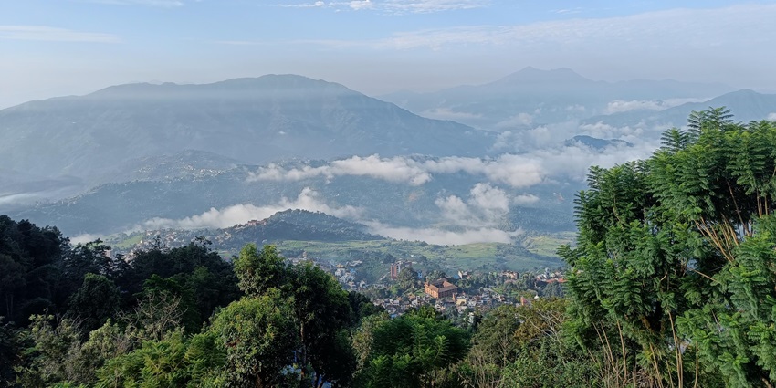 Aerial view of Gorkha town nestled in hills with misty clouds, from historic Gorkha Durbar