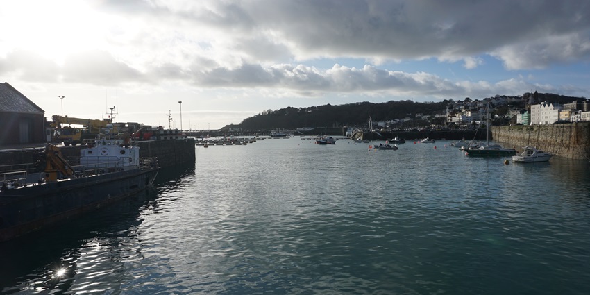A marina filled with yachts and a cruise ship on Guernsey Island in the Channel Islands.