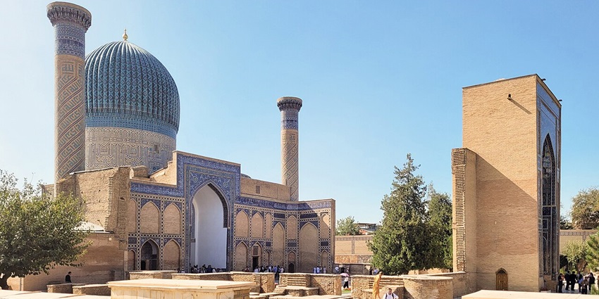 Gur-e-Amir mausoleum with traditional Islamic architecture, two minarets and people visiting