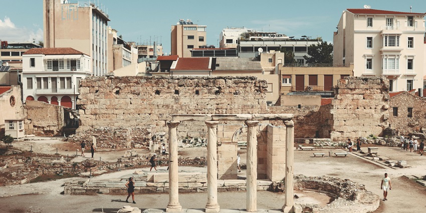 An ancient ruin with stone columns and historic buildings, one of the historical Places in Athens Greece