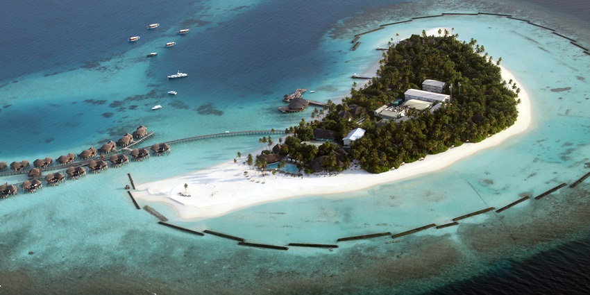 An aerial view of one of the luxurious islands in Maldives, featuring overwater villas, white sandy beaches, and lush tropical greenery