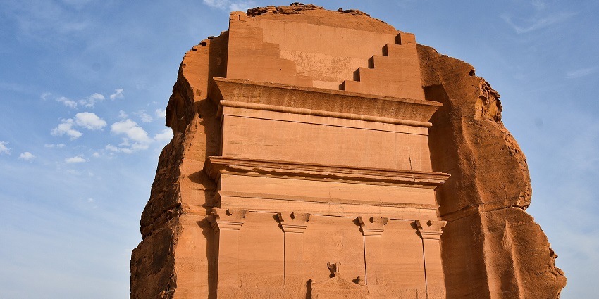 Madain Salih with ruins of a structure made up of sandstone and a small entrance gate
