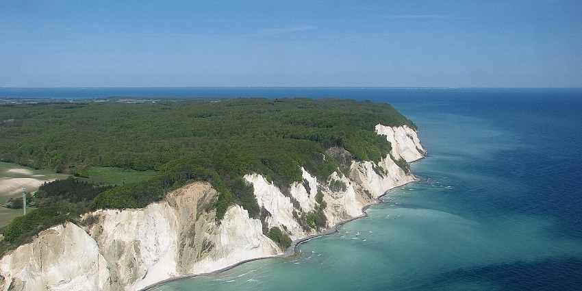 Dramatic white chalk cliffs overlooking turquoise waters, ideal for hiking and photography.