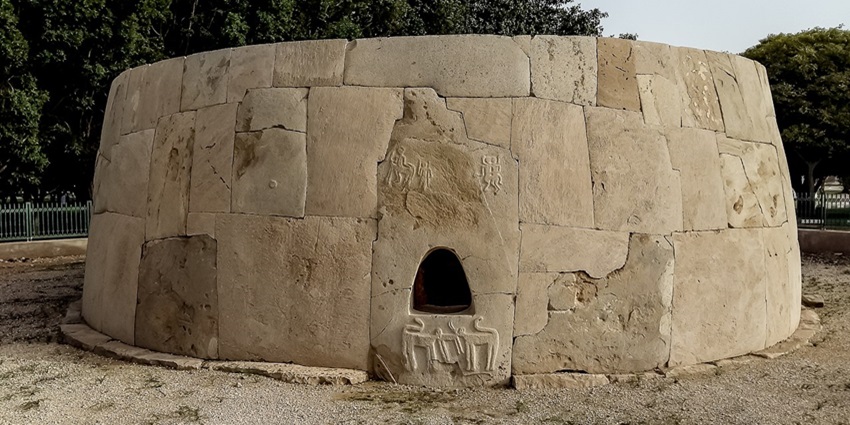 Hili Grand Tomb in Hili Archaeological Park with sandstone architecture and carvings.