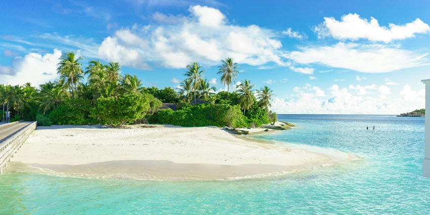 Scenic view of Himmafushi Island with palm trees, beach, and turquoise sea