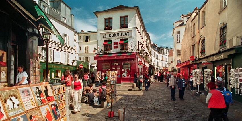 An outdoor market in Paris with stalls selling local goods and fresh produce.