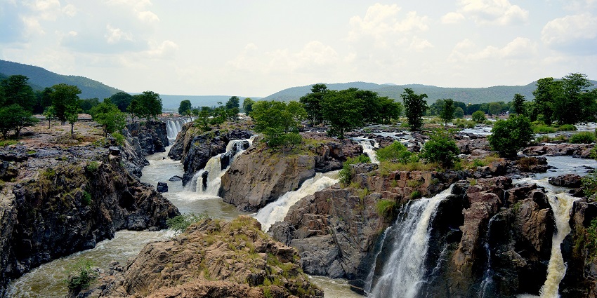 Image of dramatic cascade of Hogenakkal Falls as water crashes over rocky terrain.