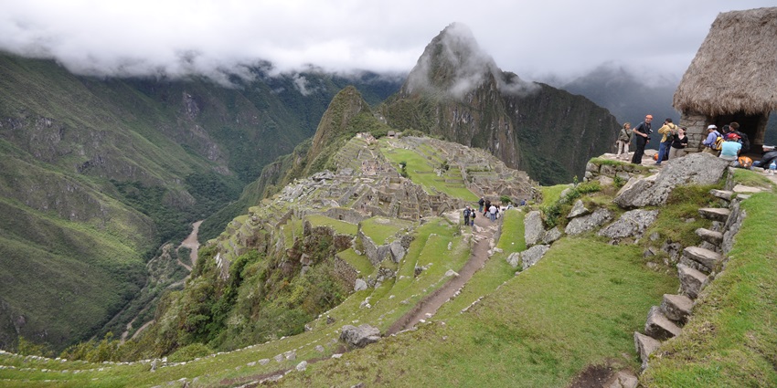 A thatched hut overlooking the carved Funerary Rock with surrounding terraces, Machu Pichu