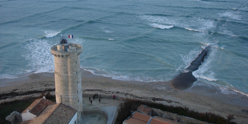 Cross sea pattern viewed from Phare des Baleines on Île de Ré, France, under blue sky