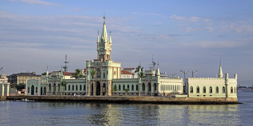 Historic waterfront building with green spires and arched windows reflected in water