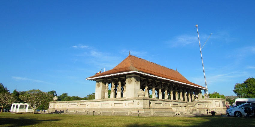 Sri Lanka Independence Square with tall white columns, a wide pathway, and green trees under a clear blue sky