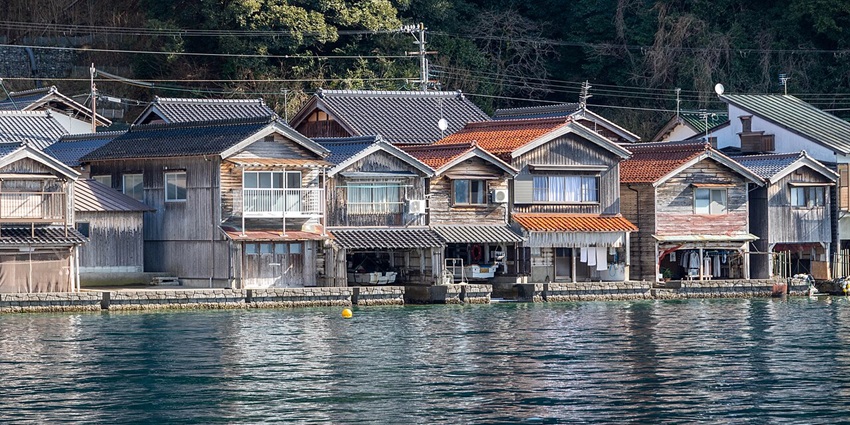 Ine no Funaya town with traditional Japanese houses, electricity wires and greenery in the back