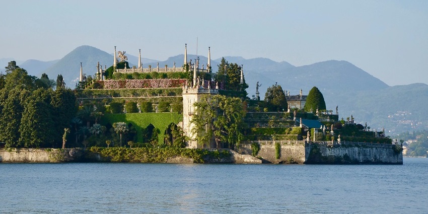 The spectacular palace of Isola Bella in Italy stands tall in its grandeur and is surrounded by calm waters.