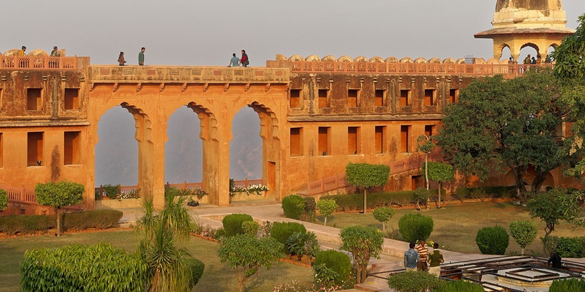Robust hill fort with canons, walls, and secret passages, overlooking Amber Fort and dense forest.