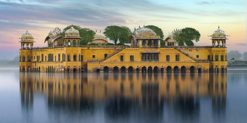 Dreamlike palace partially submerged in Man Sagar Lake, surrounded by mist and monsoon reflections.