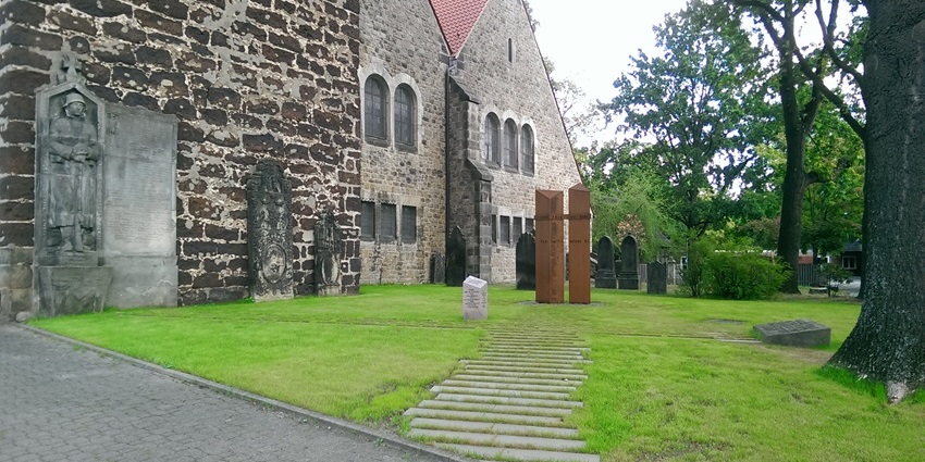 Peace memorial with traditional architecture buildings, stone signage and tall green trees
